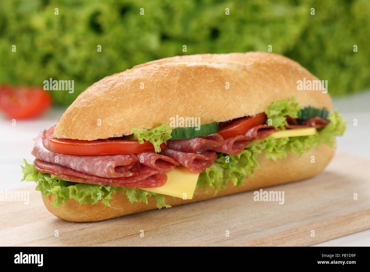 Sub deli sandwich baguette con salame, formaggio, pomodori e lattuga Foto Stock