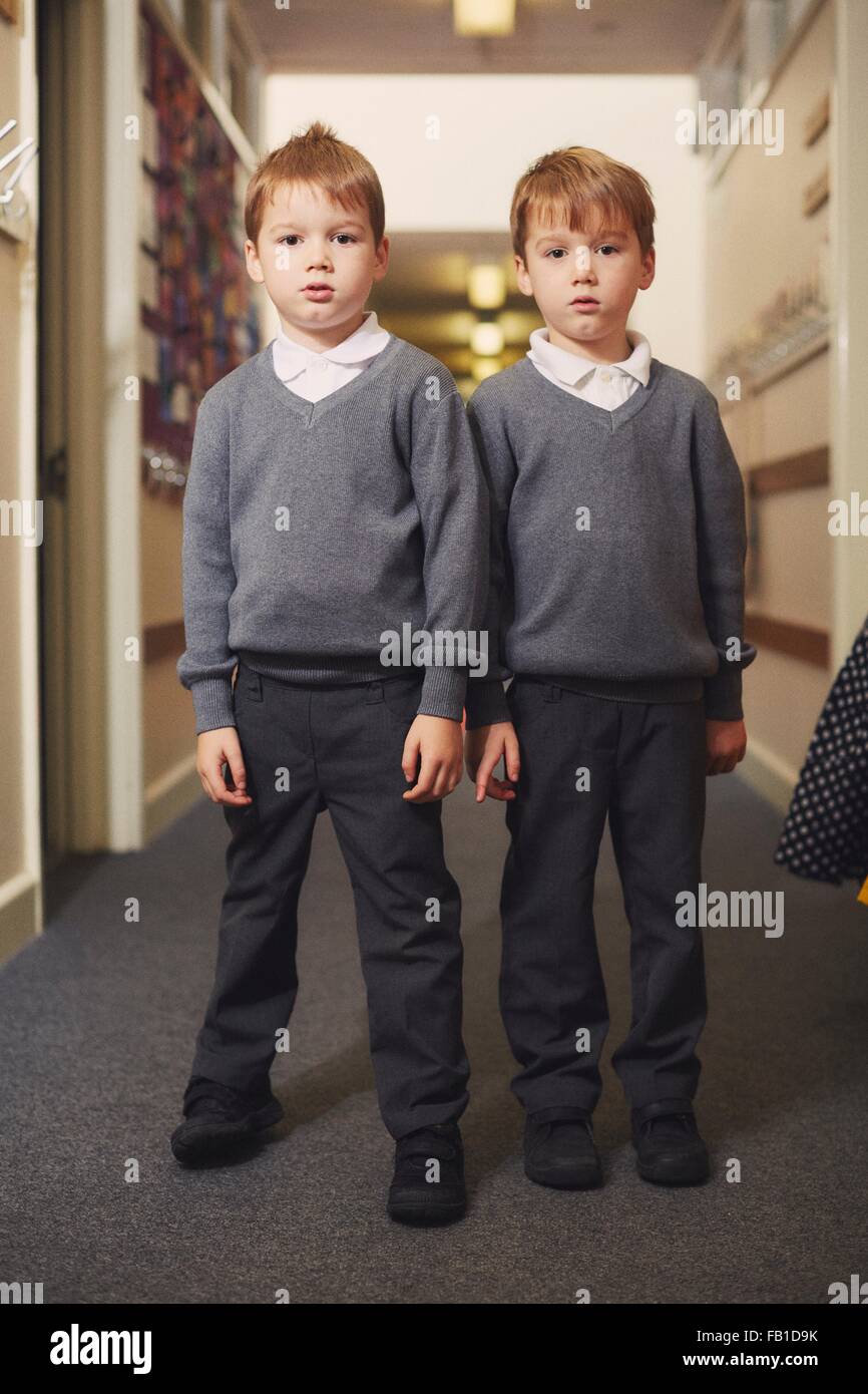 Ritratto di elementare schoolboy gemelli nel corridoio della scuola Foto Stock