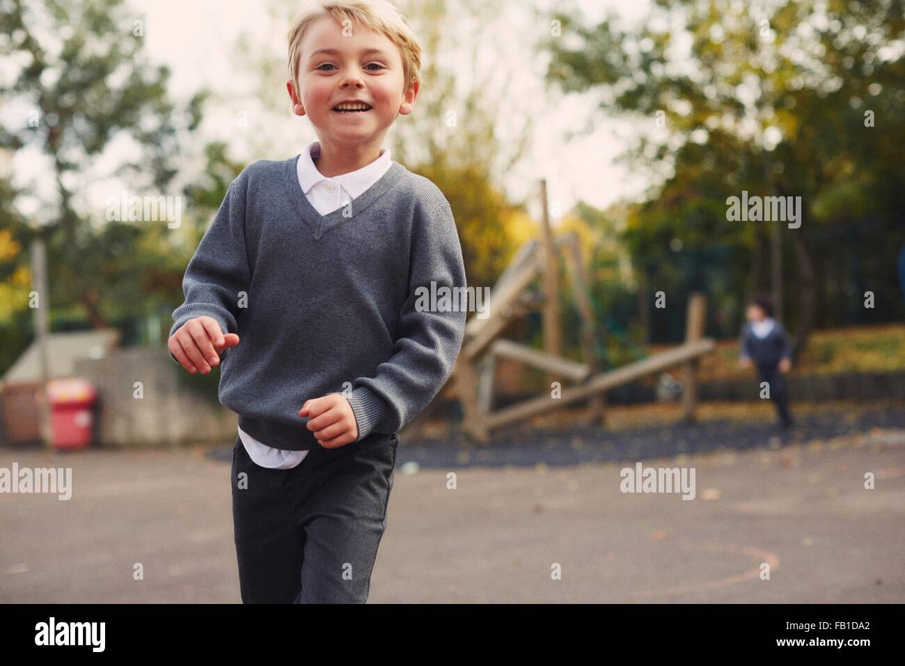 Ritratto di elementare schoolboy in esecuzione nel parco giochi Foto Stock