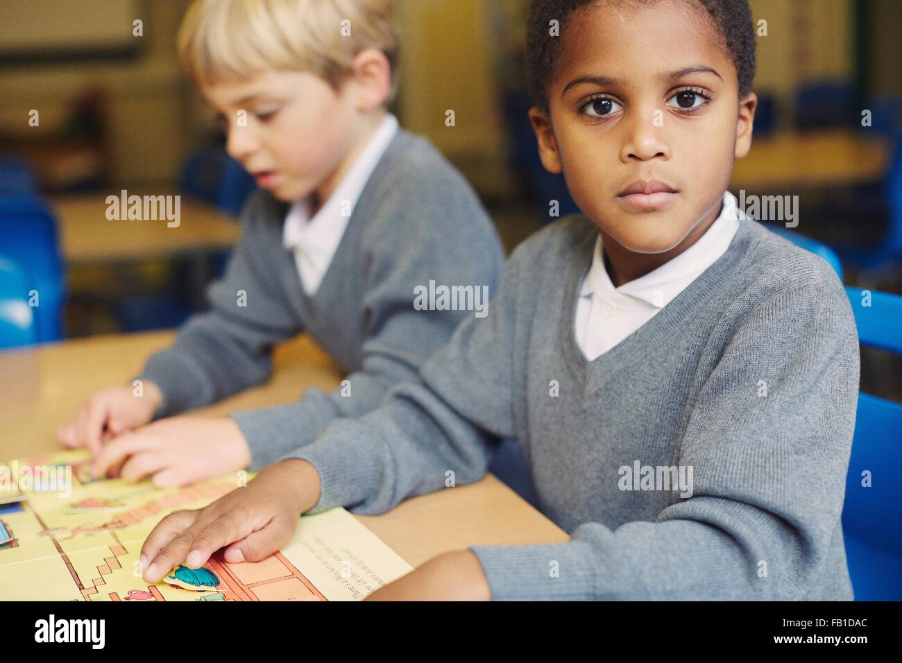 Ritratto di ragazzo facendo puzzle al desk nella scuola elementare classroom Foto Stock