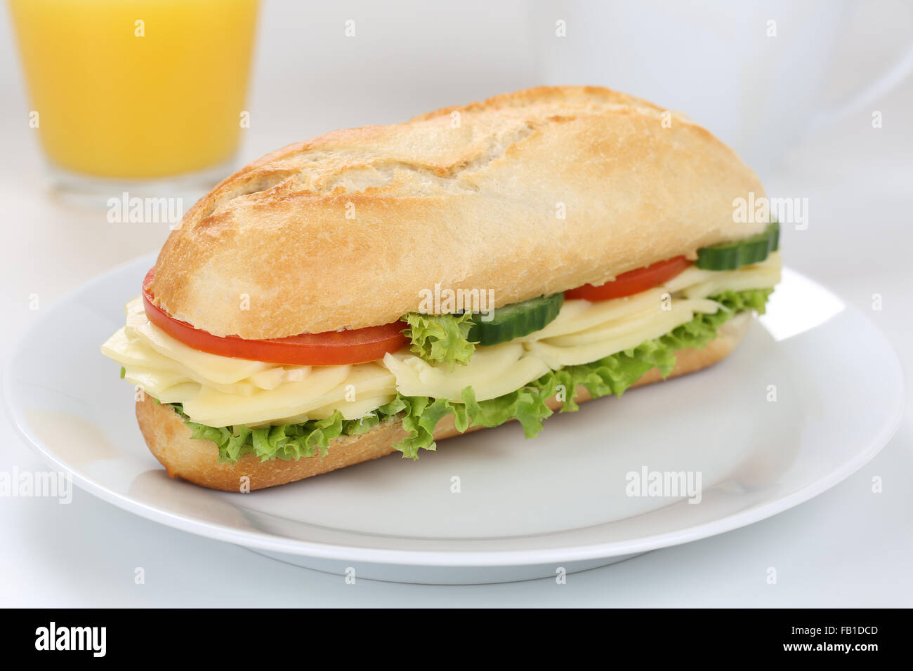 Sub deli sandwich baguette per colazione con formaggio, pomodori, lattuga e succo di arancia Foto Stock