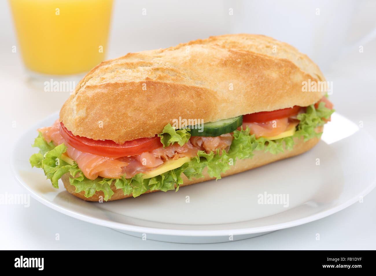 Sub deli sandwich baguette per colazione con salmone pesce, formaggio, pomodori, lattuga e succo di arancia Foto Stock