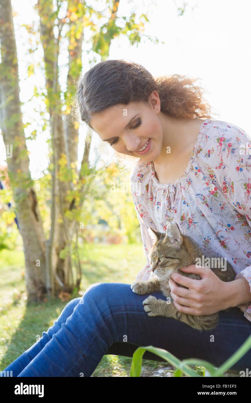 Ragazza adolescente relax nel giardino petting cat Foto Stock