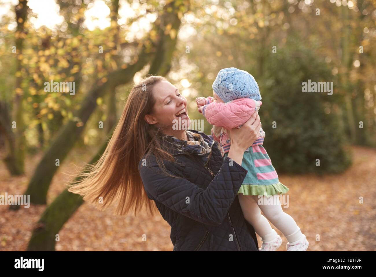 Metà donna adulta swinging bimba in autunno park Foto Stock