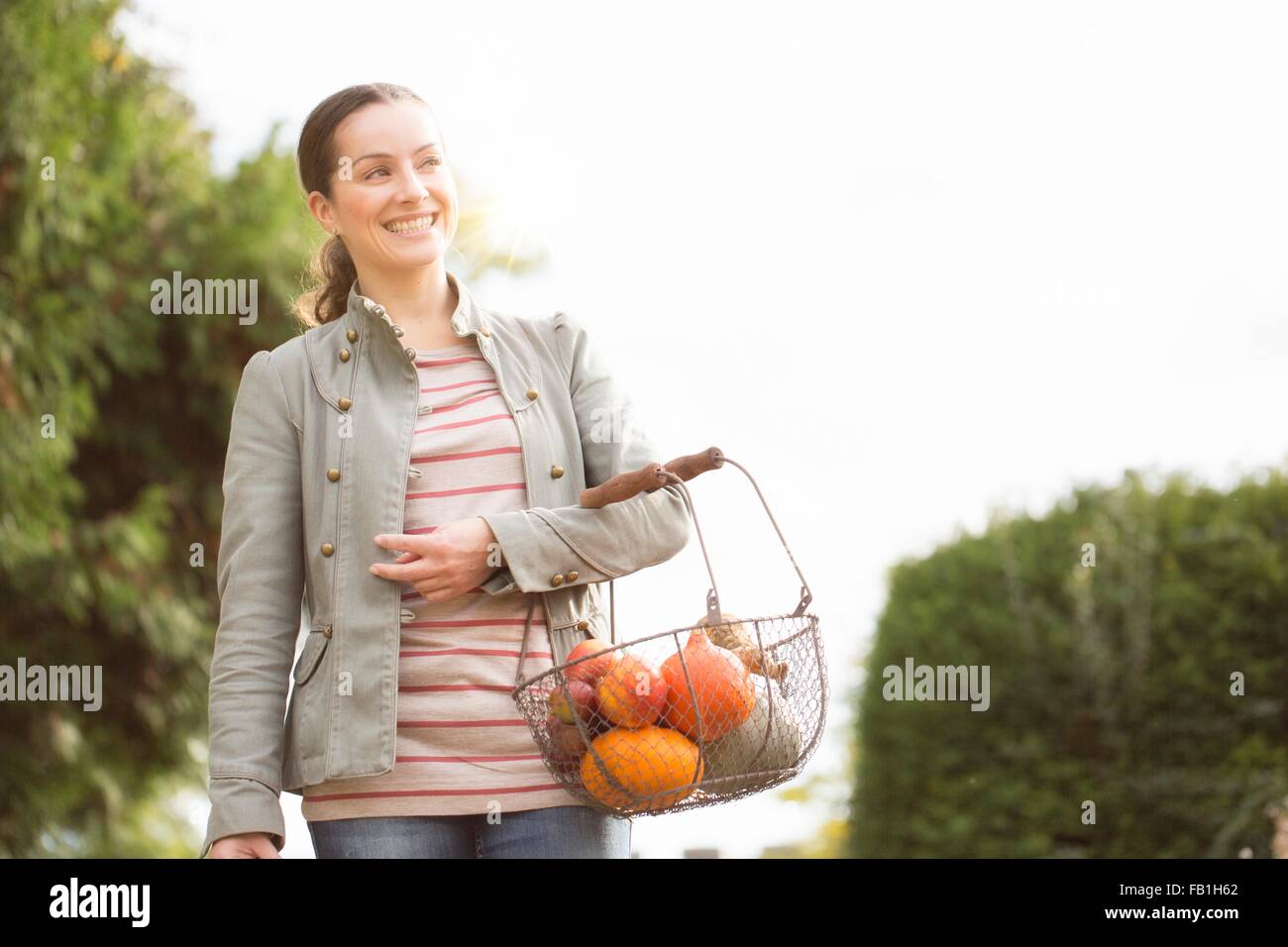 Donna che trasportano cesto di frutta e verdura Foto Stock