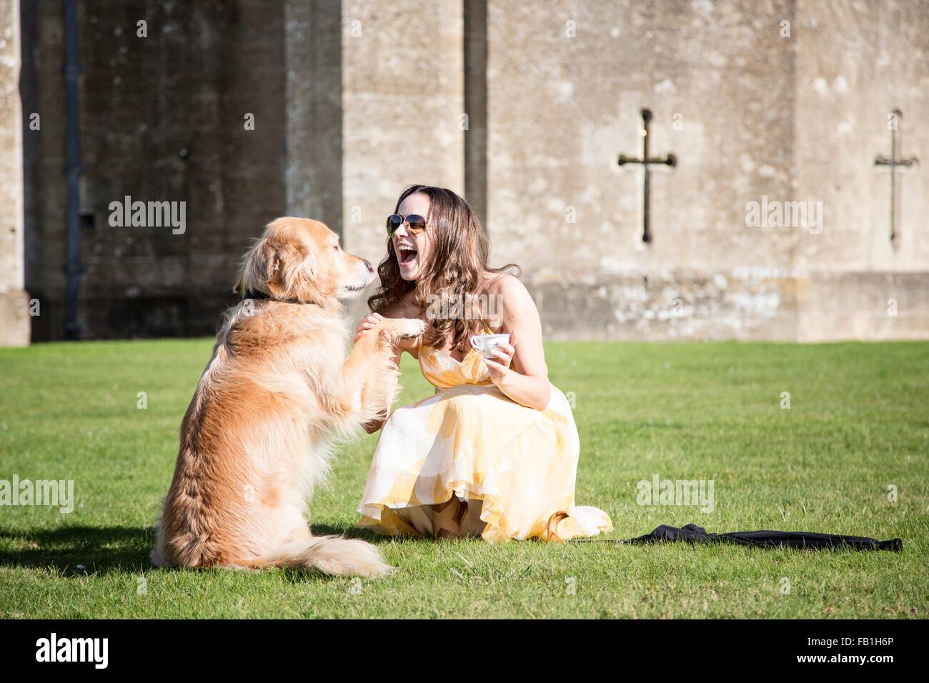 Donna in posa con la tazza di tè e golden retriever cane a Thornbury Castle, South Gloucestershire, Regno Unito Foto Stock