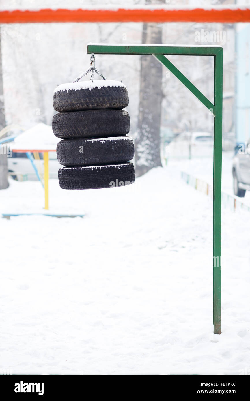 Boxe pera appeso realizzato da pneumatici incatenato all'esterno. La formazione e l'indurimento per lo spirito di lotta in qualsiasi condizione meteo. Street trainer per un allenamento, fai da te. Foto Stock