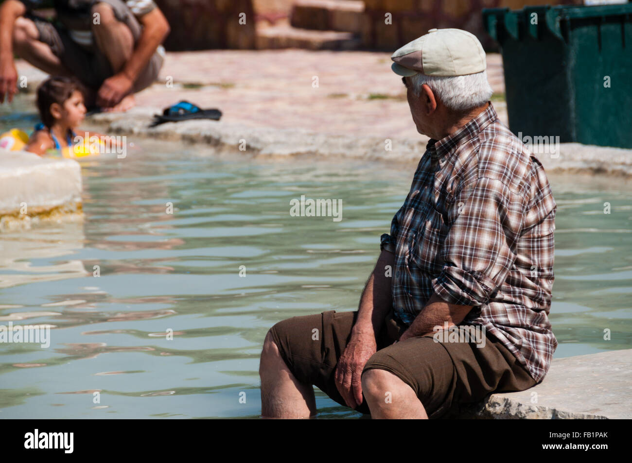 Il vecchio uomo turco con hat seduta in primavera calda Foto Stock