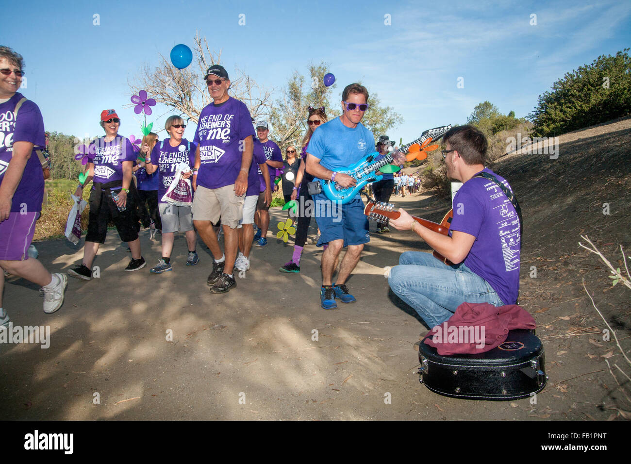 Musicisti volontari intrattenere i partecipanti in una raccolta fondi di beneficenza per le vittime dell'Alzheimer come si cammina in una Laguna Niguel, CA, parco. Nota viola commemorative T-shirt assegnati per le donazioni. Foto Stock