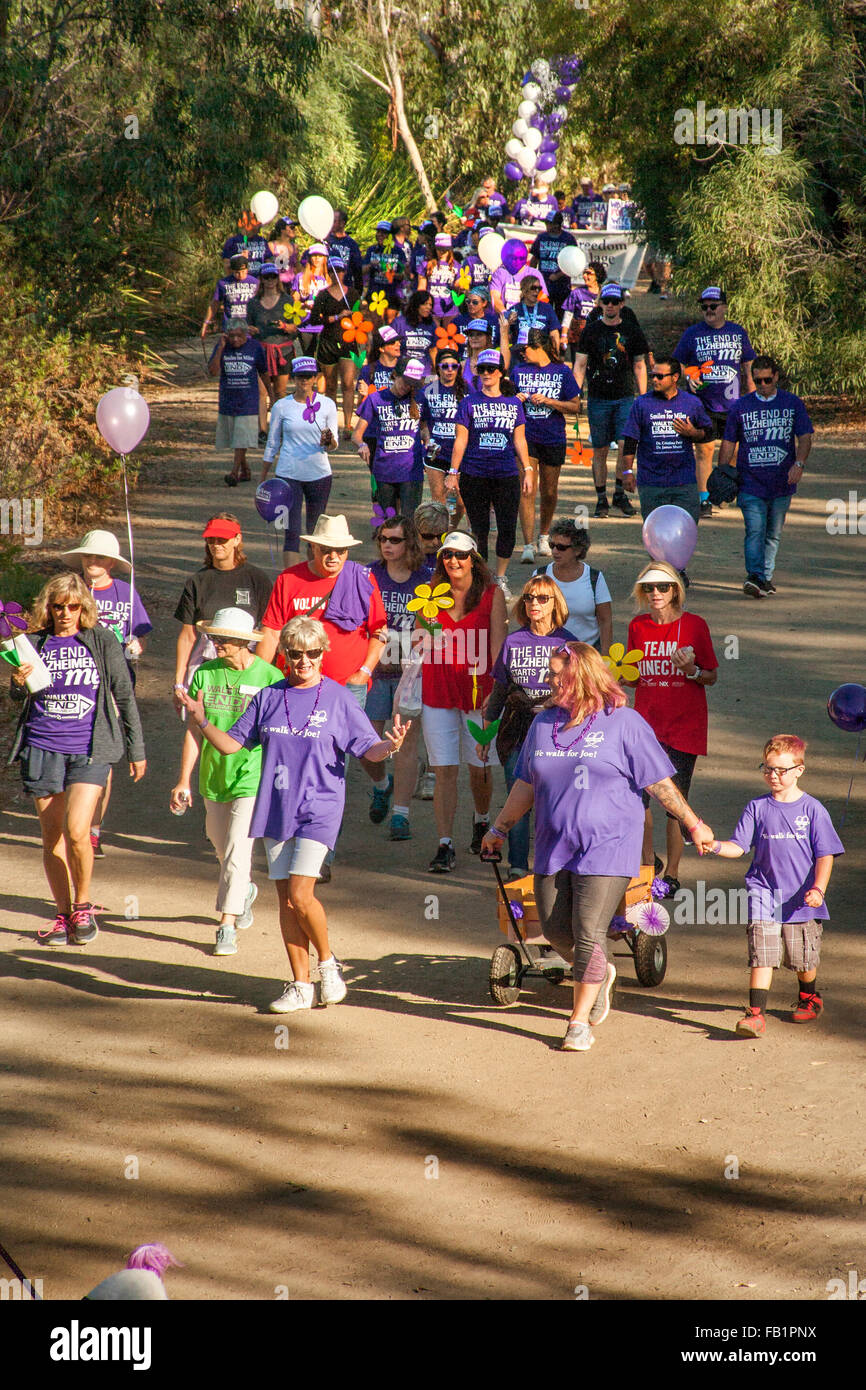 I partecipanti in una raccolta fondi di beneficenza per le vittime dell'Alzheimer a piedi in una Laguna Niguel, CA, parco. Nota viola commemorative T-shirt assegnati per le donazioni. Foto Stock