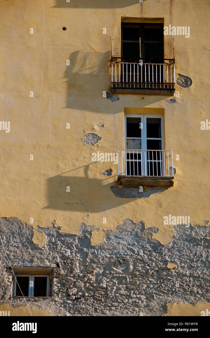 Italiano antico in pietra gialla davanti casa con balcone e finestra Foto Stock