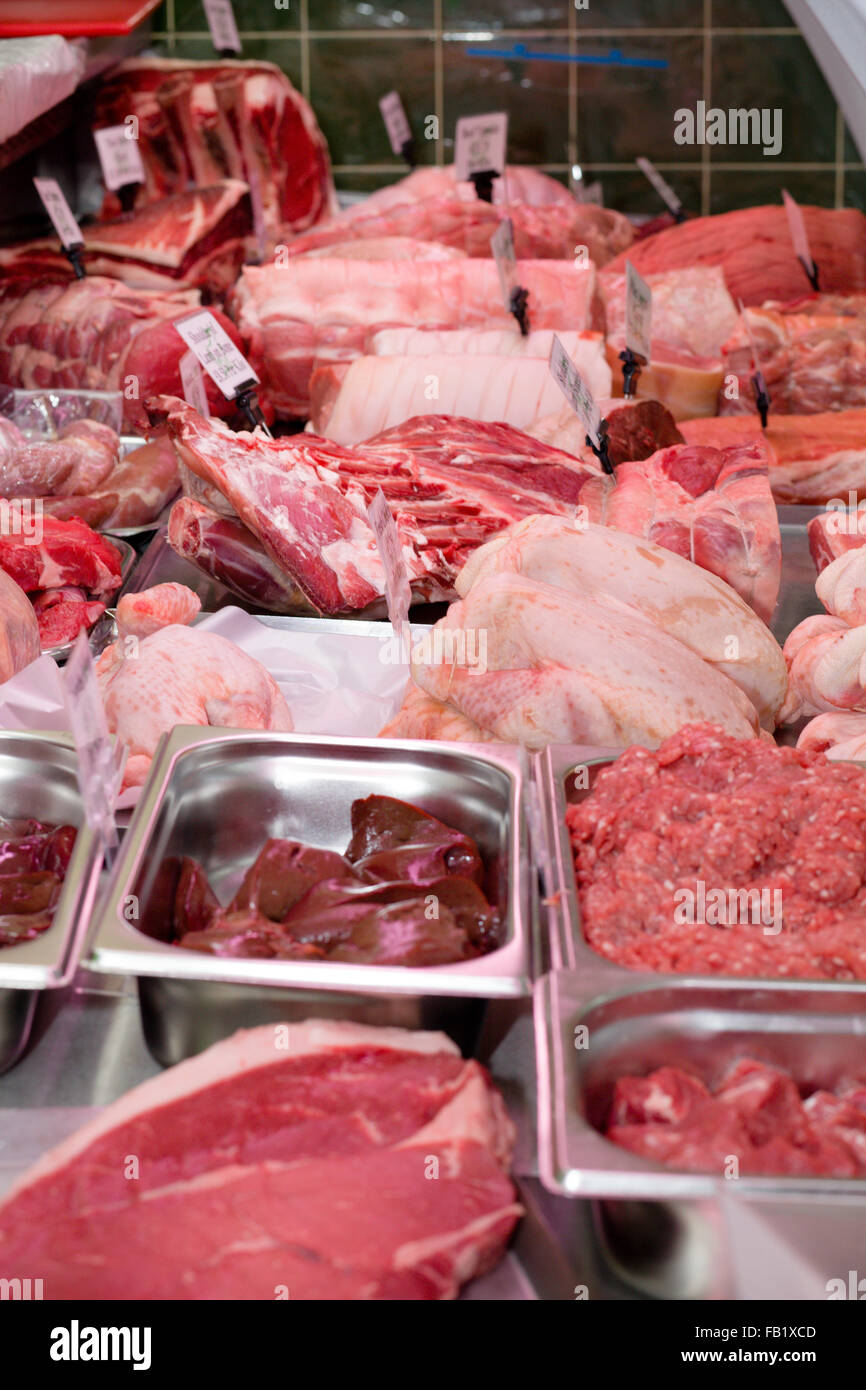 Le mani di taglio/sfilettatura carne preparata per essere venduto in un negozio di macellaio Foto Stock