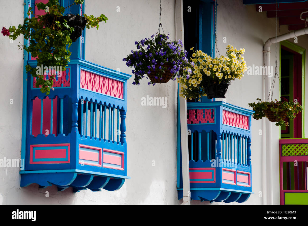 Colorato di blu e di rosso davanti casa con fiori sul balcone nel Salento Foto Stock