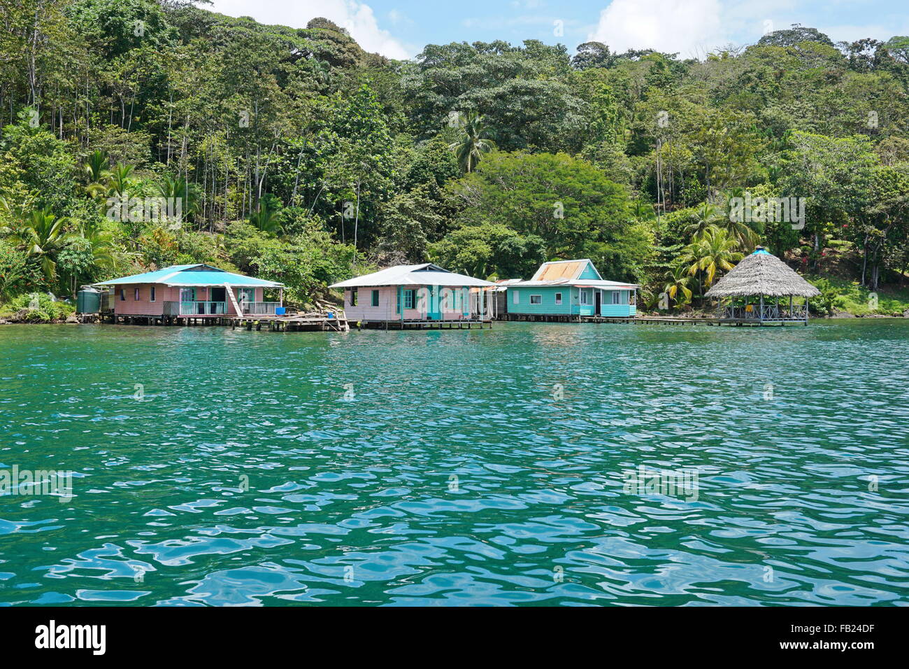 Lussureggiante tropicale shore con case rustiche sul mare, Bocas del Toro, Costa Caraibica di Panama, America Centrale Foto Stock