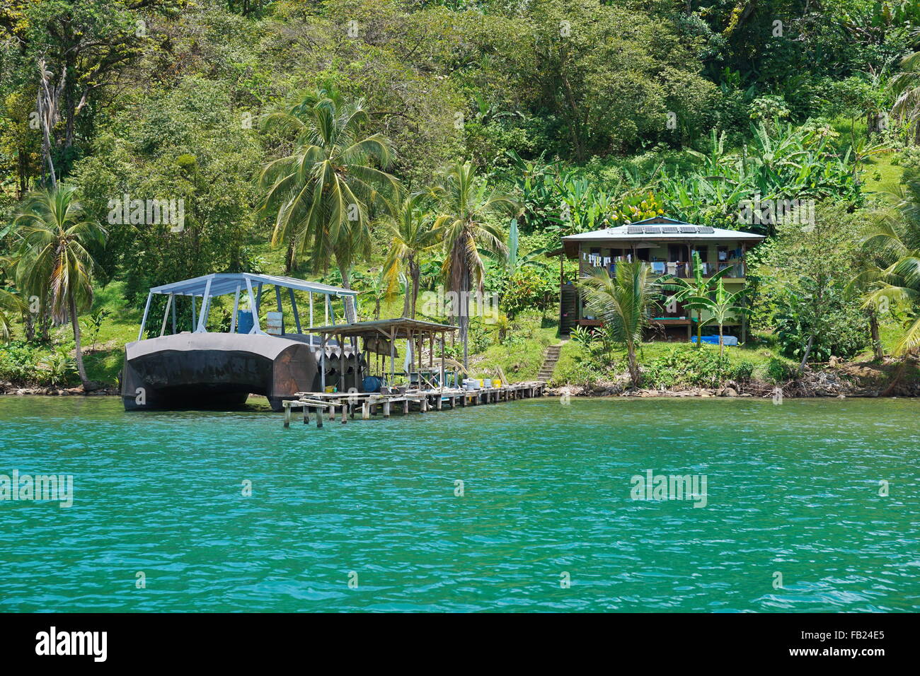 Costa Tropicale con un off-grid house e strana imbarcazione al dock in un isola dei Caraibi costa di Panama, America Centrale Foto Stock