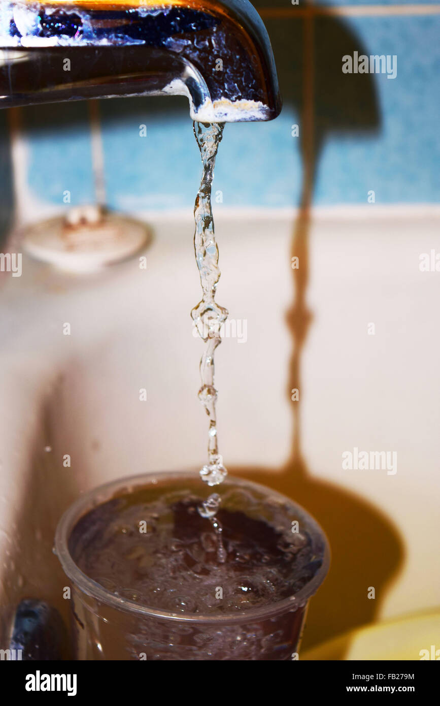 Acqua che scorre da un rubinetto del bagno Foto Stock