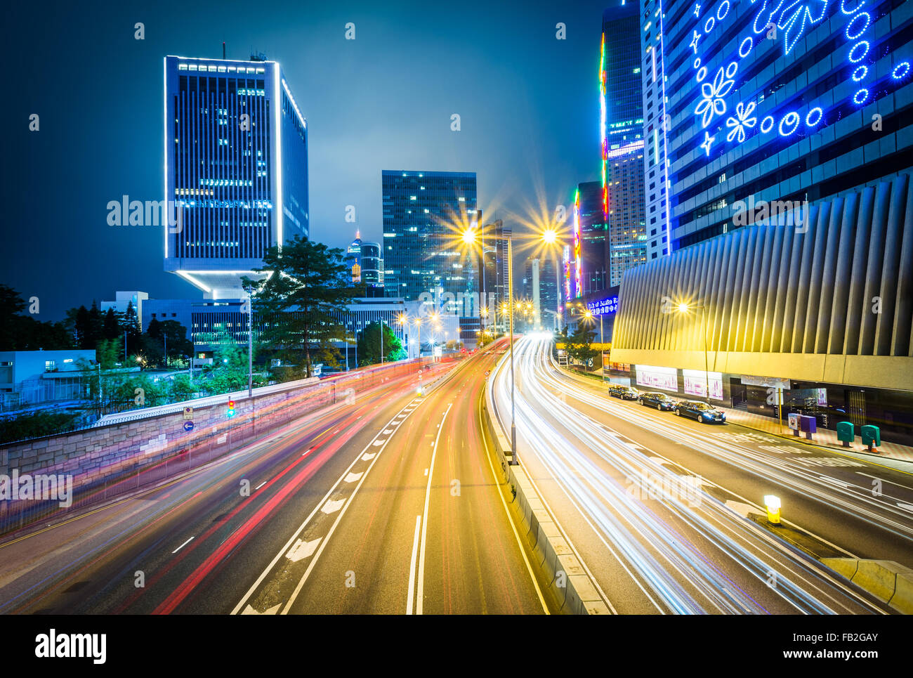 Una lunga esposizione di traffico su Connaught Road e grattacieli di notte, a Hong Kong, Hong Kong. Foto Stock