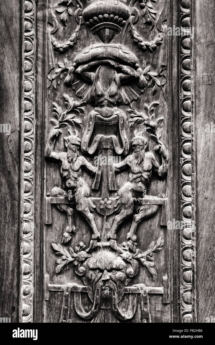 Dettaglio del vecchio cancello in legno intagliato con figure demoniaca. Foto Stock