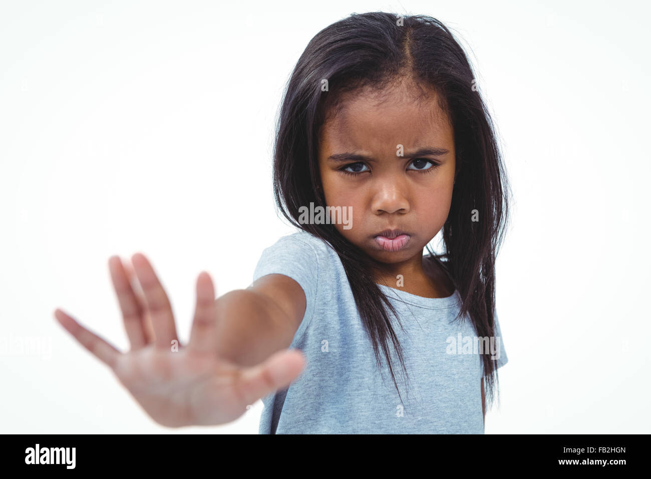 Ragazza rendendo grimace tenendo la mano alla telecamera Foto Stock