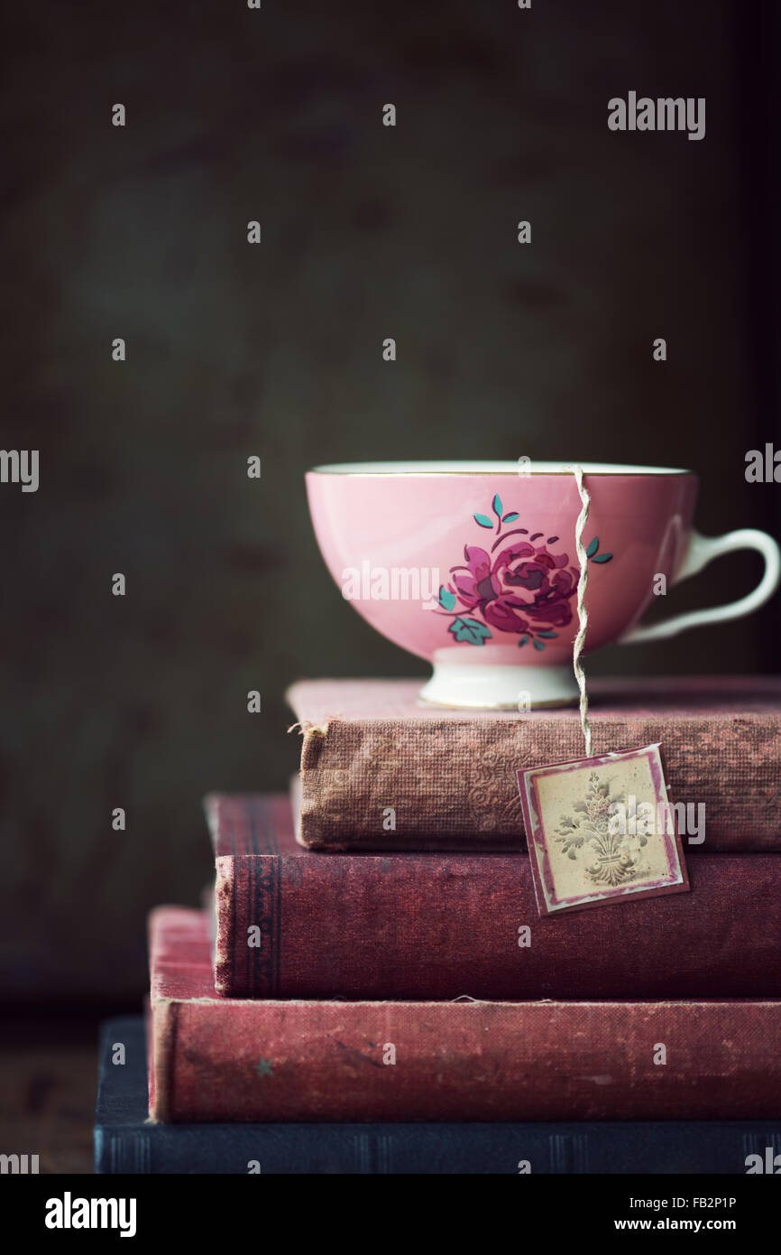 Vintage tazzina sulla pila di libri antichi Foto Stock