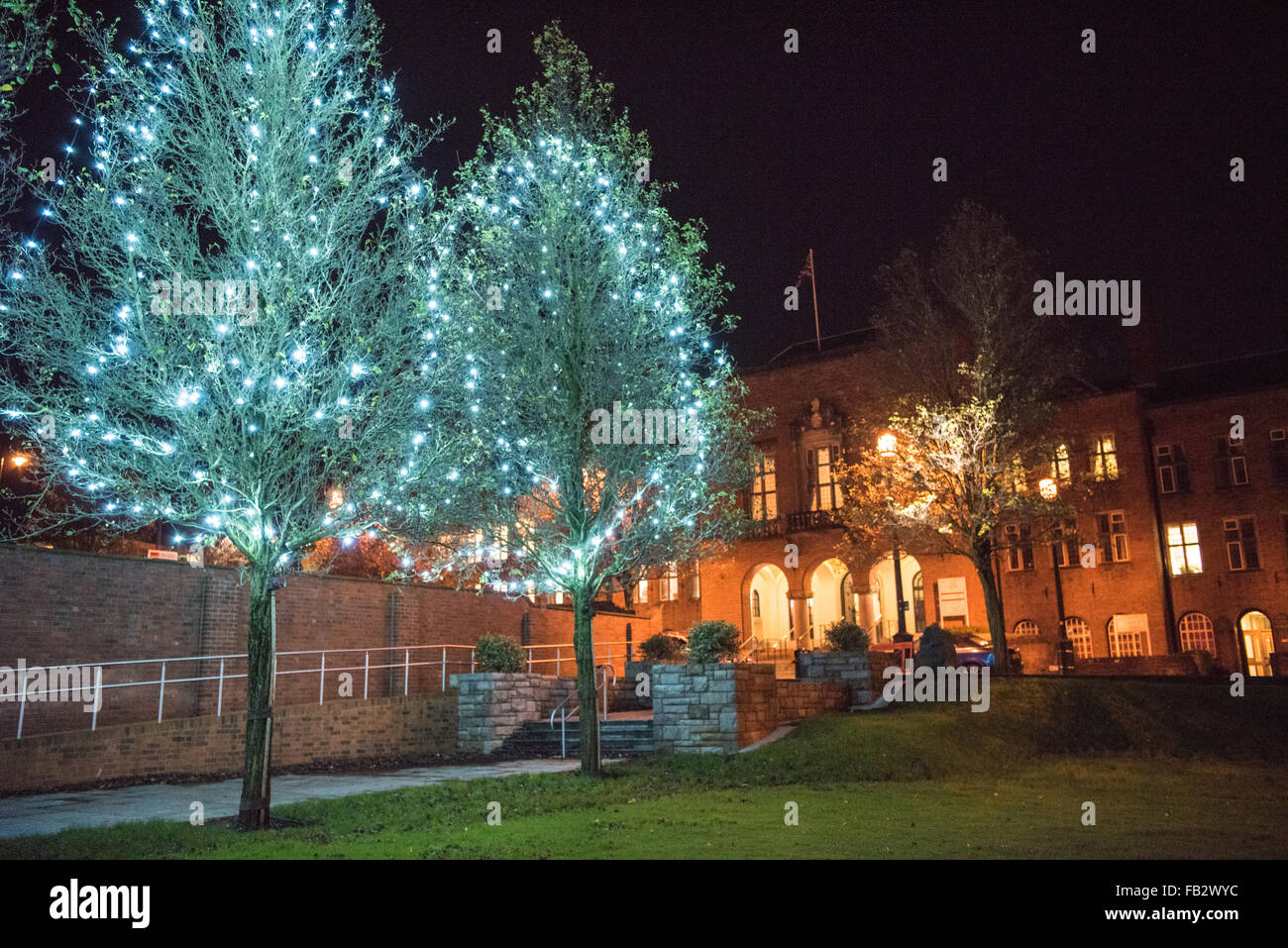 Dudley Casa Consiglio illuminata di notte e di una fila di alberi in Priory Park con le luci di Natale a decorarle Foto Stock