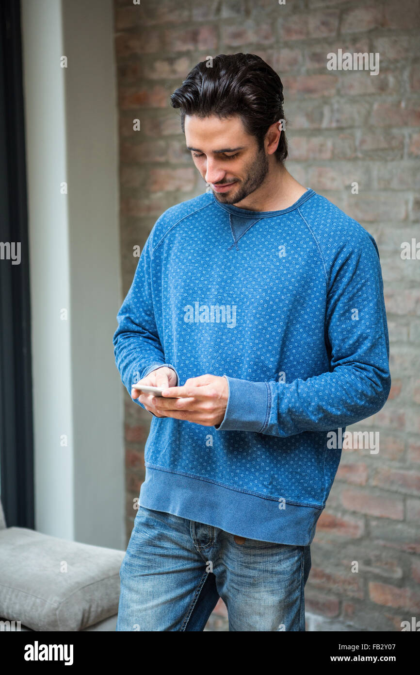 Bel uomo utilizza lo smartphone Foto Stock