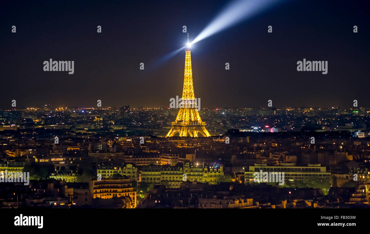Parigi di notte elevata dello skyline della città oltre i tetti degli illuminati dalla torre Eiffel, Francia, Europa Foto Stock