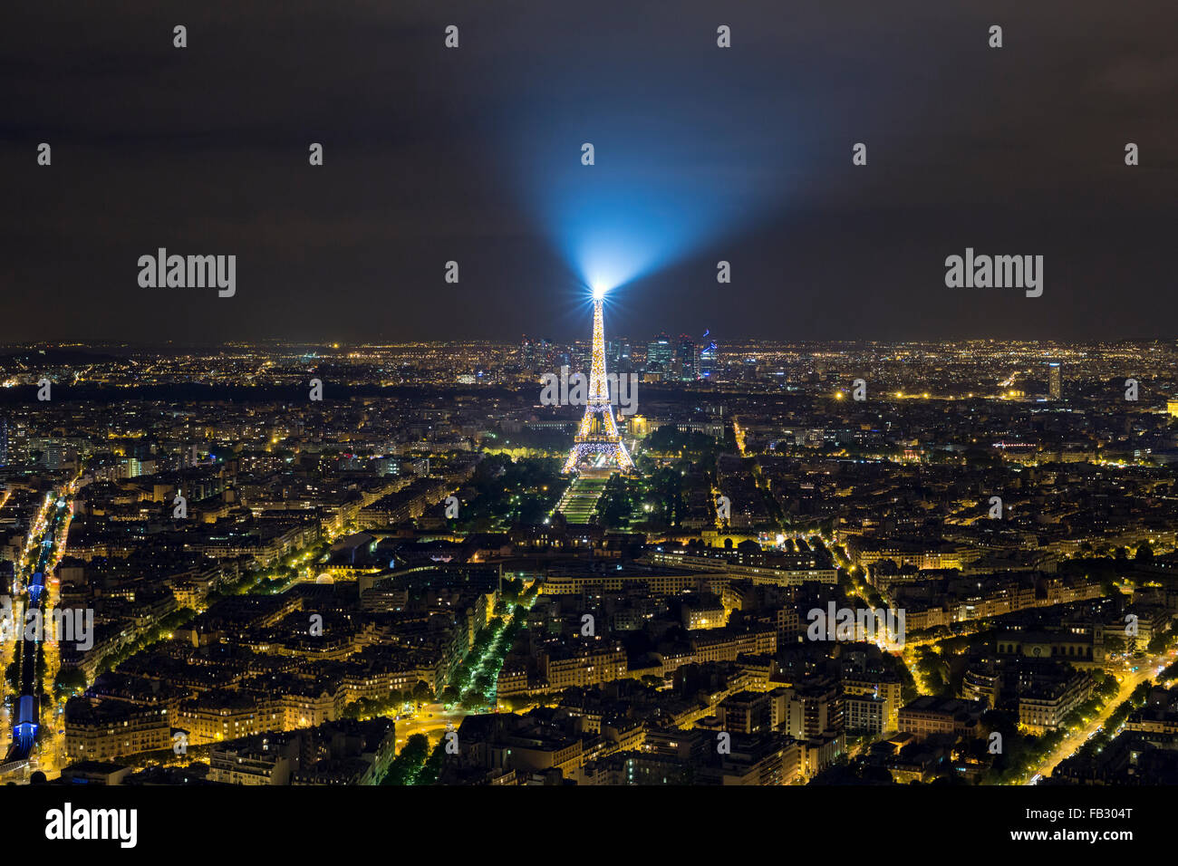 Vista in elevazione dell'illuminato dalla Torre Eiffel, notte dello skyline della città e distante La Defense grattacielo, Parigi, Francia, Europa Foto Stock