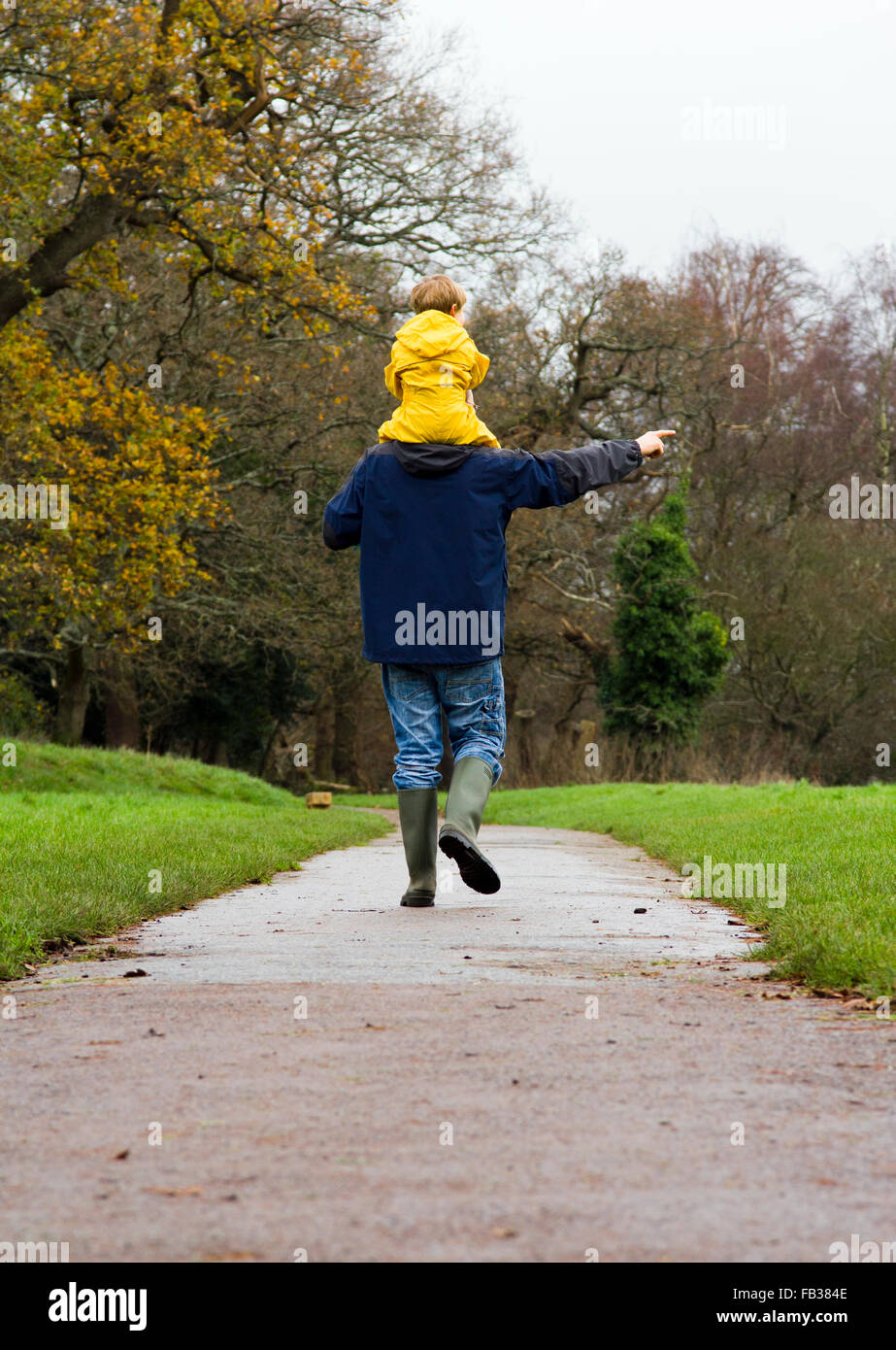 Padre e figlio facendo una passeggiata invernale in un parco a Bristol, Regno Unito Foto Stock