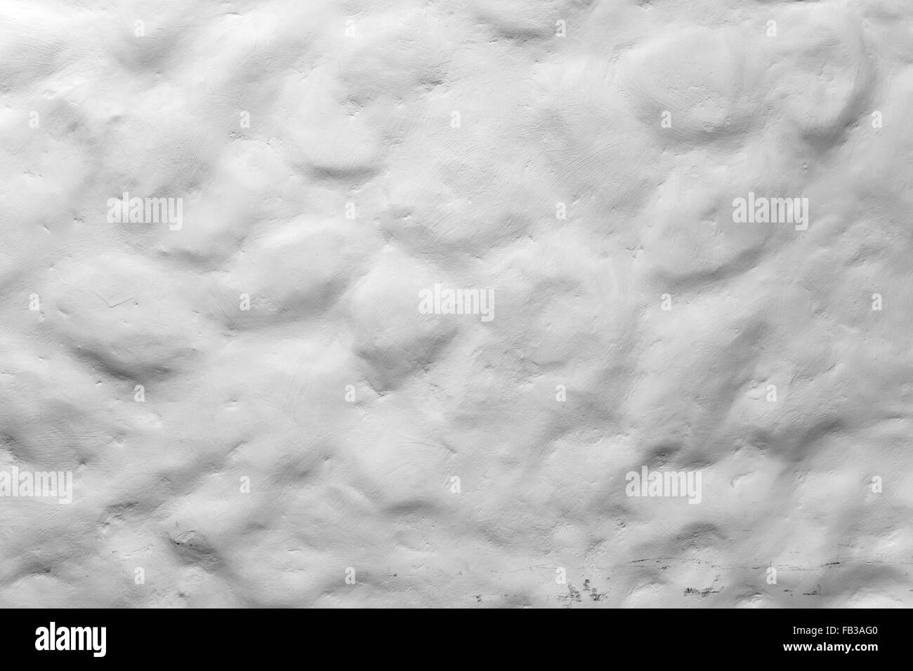 Ruvida irregolare dipinte di bianco muro di pietra, closeup foto di sfondo texture Foto Stock