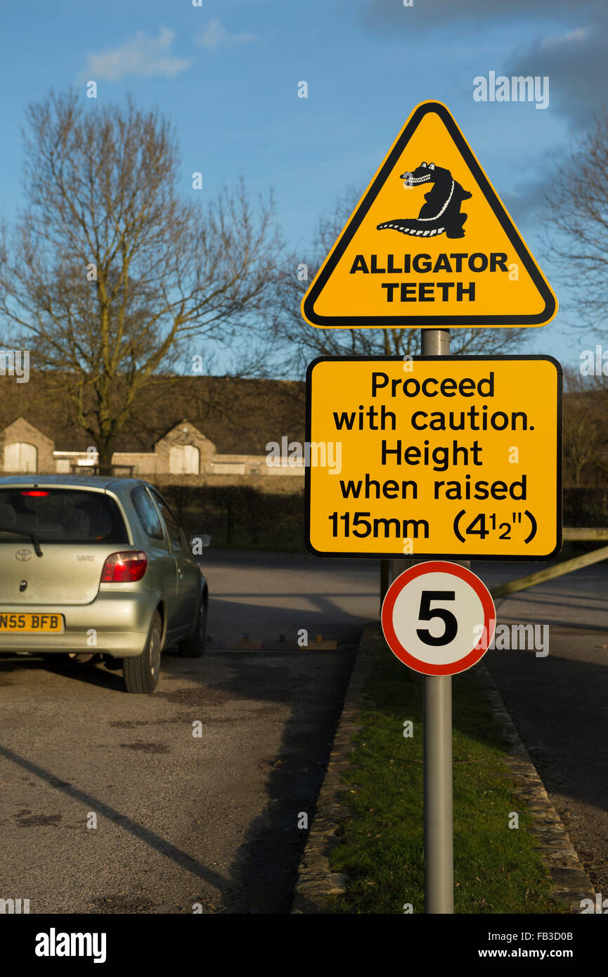 Guida auto oltre i denti del coccodrillo di direzione del traffico enforcer con simbolo giallo di avvertimento - il parco auto uscire, Bolton Abbey, North Yorkshire, GB, UK. Foto Stock