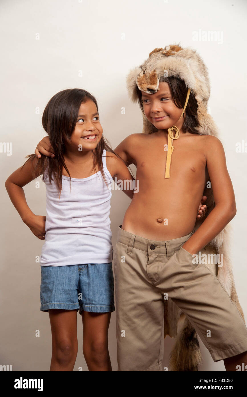 Un nativo americano un ragazzo e una ragazza, entrambi membri della tribù Acjachemen, si pone come un affettuoso giovane. Nota testa di coyote costume sul ragazzo, adatto per maschio usura tribali. Modello di rilascio Foto Stock
