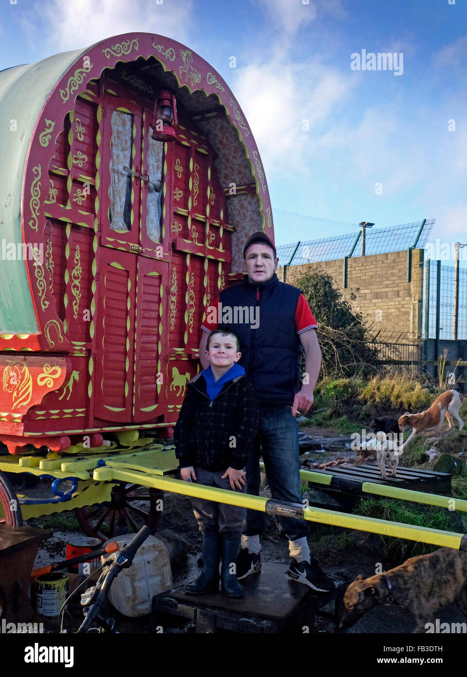 Un padre e un figlio del viaggiatore irlandese si trovano al di fuori della carovana trainata da cavalli o del vagone coperto. Precedentemente conosciuto come tinkers. Foto Stock
