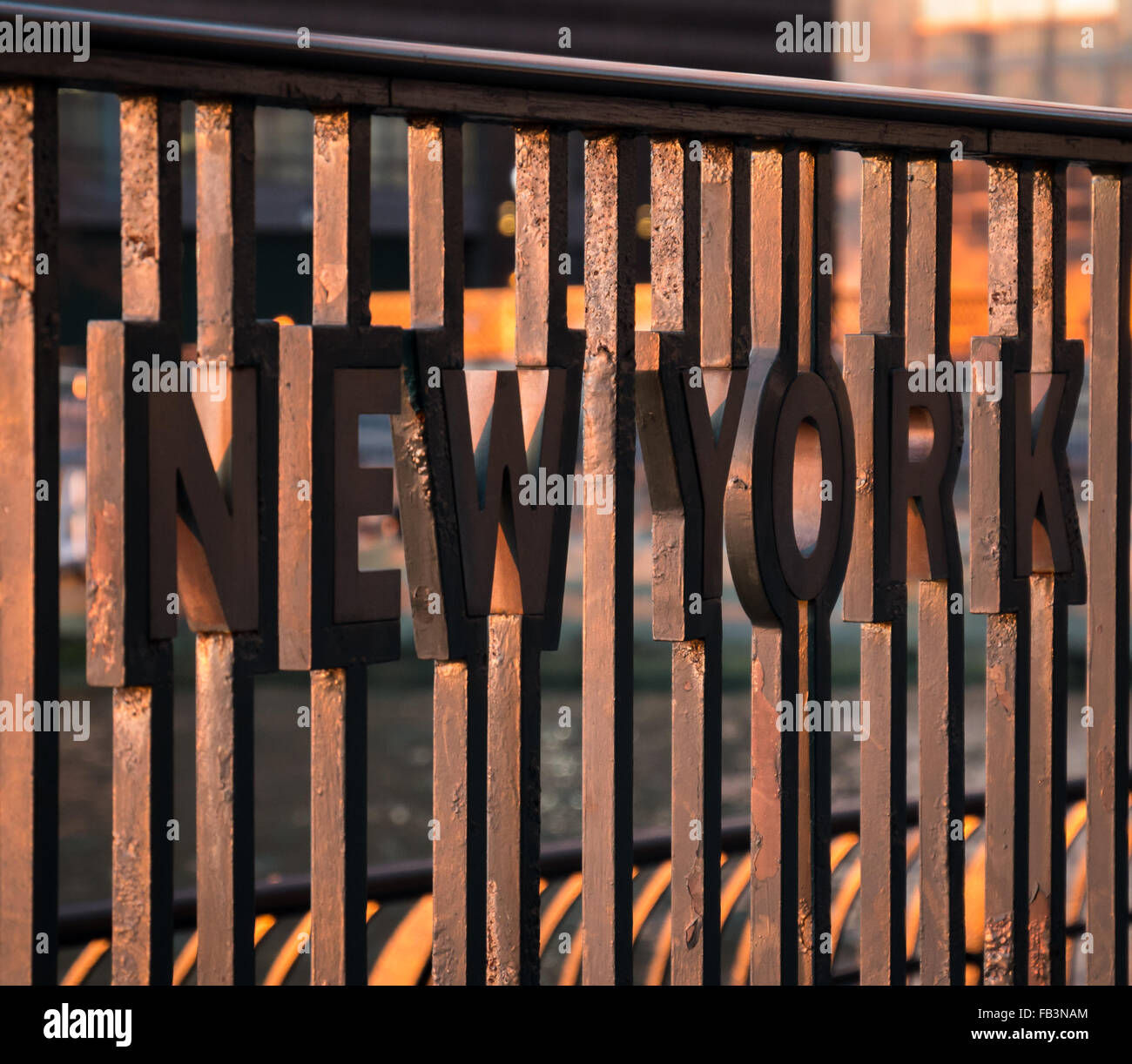 Close up di 'New York' inset in metallo ringhiere presso il World Financial Center Plaza con il fiume Hudson shot al tramonto. Foto Stock