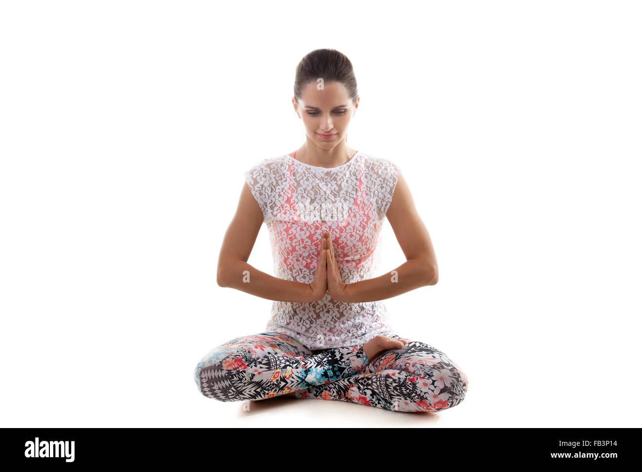 Lo Yoga girl su sfondo bianco in sukhasana (facile Posa Posa decente, piacevole posa) archi Foto Stock