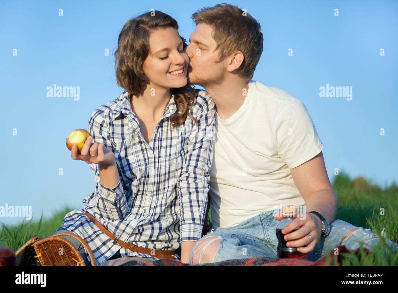 Accoppiare il picnic, guy baci ragazza sulla guancia Foto Stock