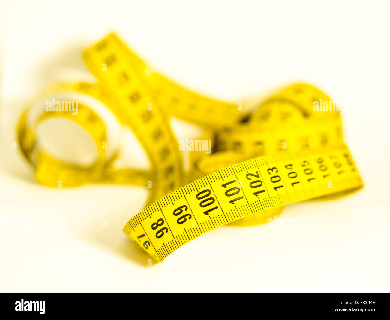 Ancora in vita con un nastro giallo misurare con i numeri da centinaia e centinaia di uno in primo piano, un simbolo di successo e obiettivo Foto Stock