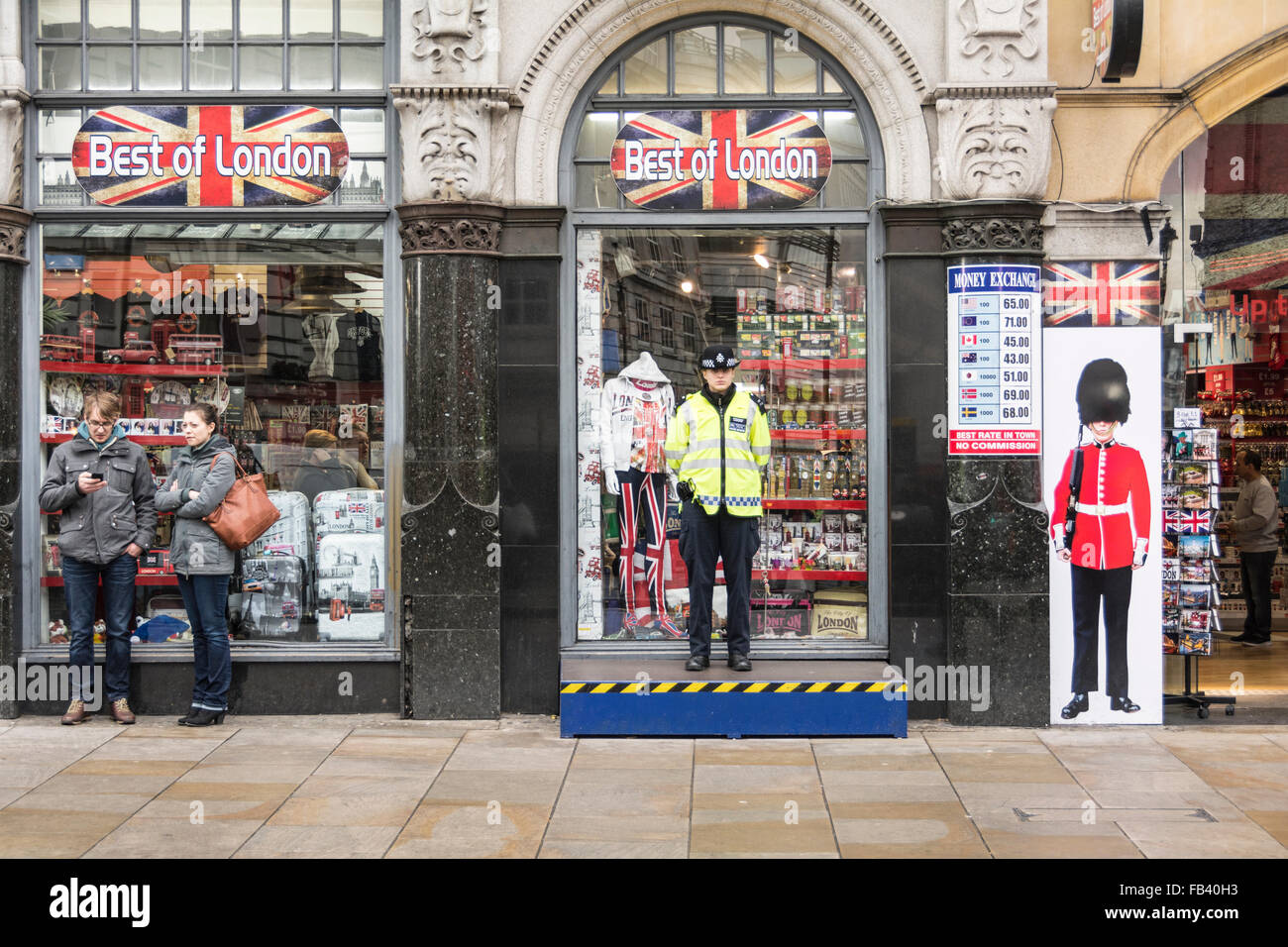 Un poliziotto fa un'indagine su tutti i suoi aspetti da una piattaforma sopraelevata nel centro di Londra vicino al Piccadilly Circus di Londra. Foto Stock