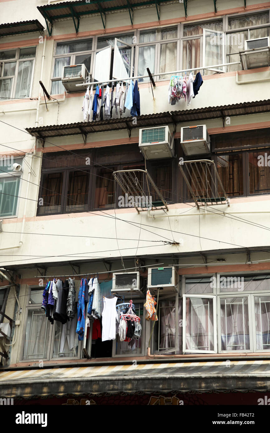 Si tratta di una foto di un dettaglio di un edificio del distretto di Kowloon a Hong Kong, Cina. Possiamo vedere impiccati i vestiti si asciuga Foto Stock