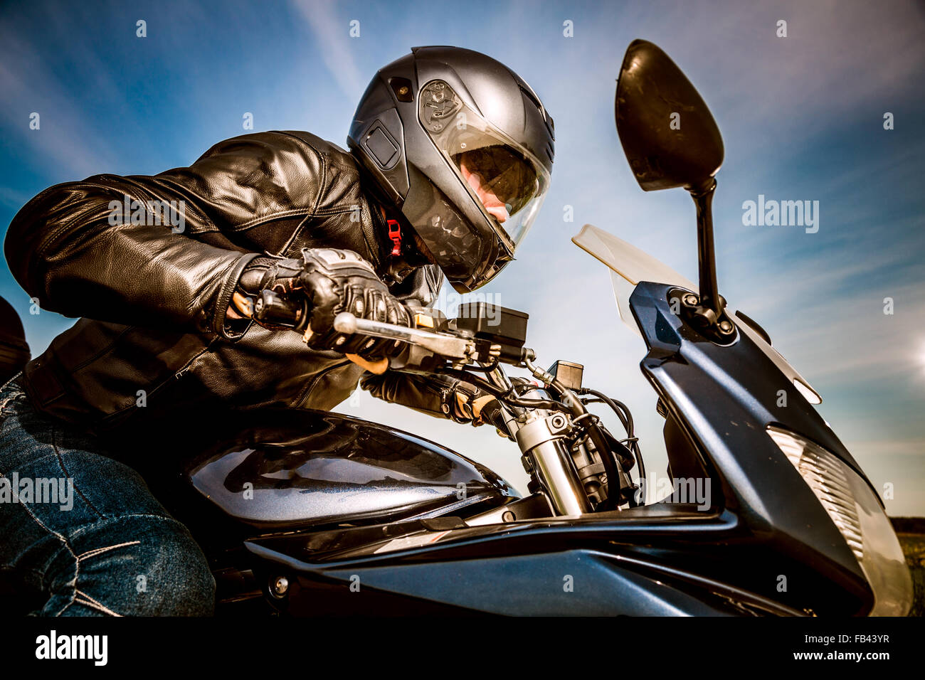 Biker in casco e giacca di pelle racing su strada Foto Stock Biker in casco e giacca di pelle racing su strada Foto Stock
