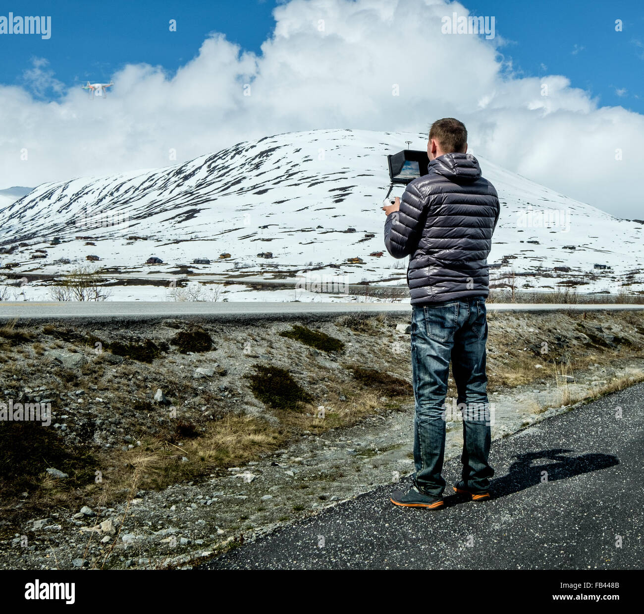 I comandi pilota il fuco esecuzione di volo sopra le montagne Foto Stock