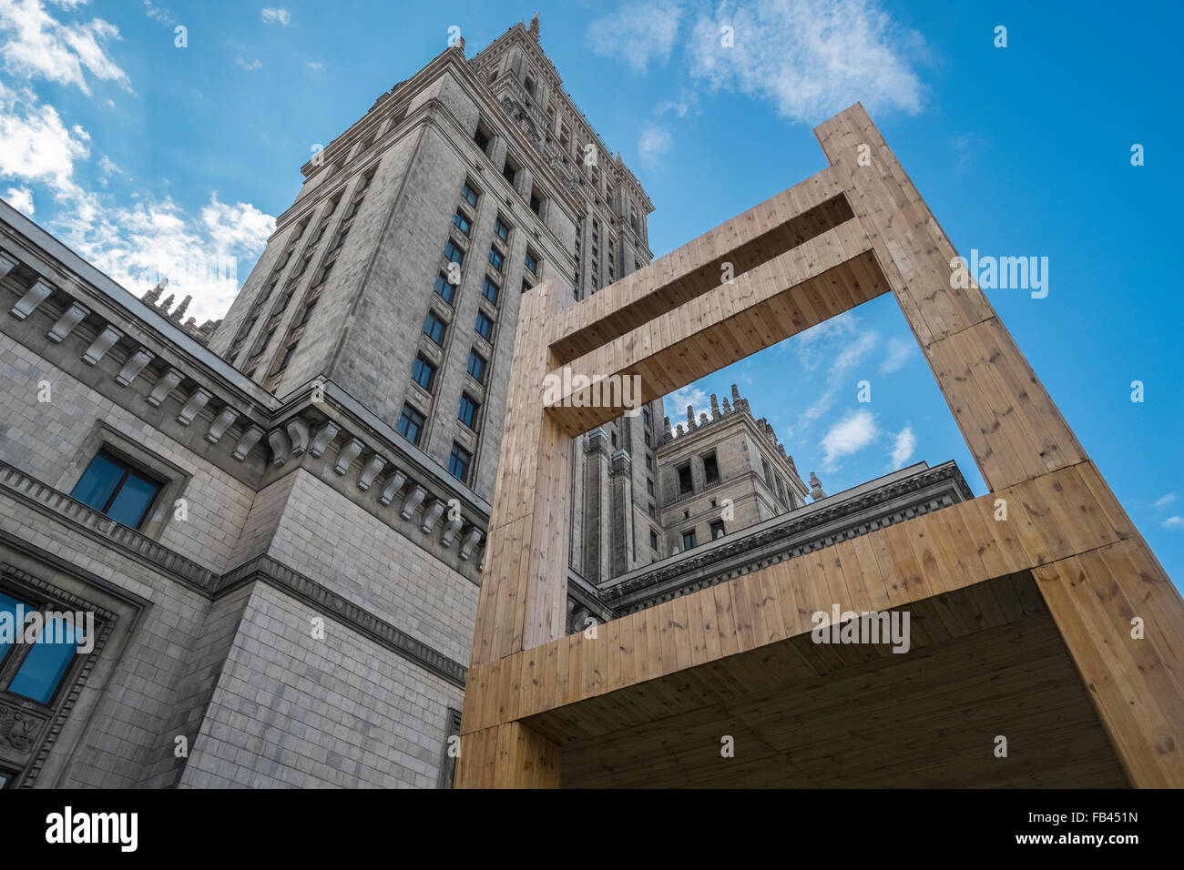 Varsavia il palazzo della cultura e della scienza edificio, un esempio di architettura stalinista, con sedia gigante arte di installazione nelle vicinanze. Foto Stock