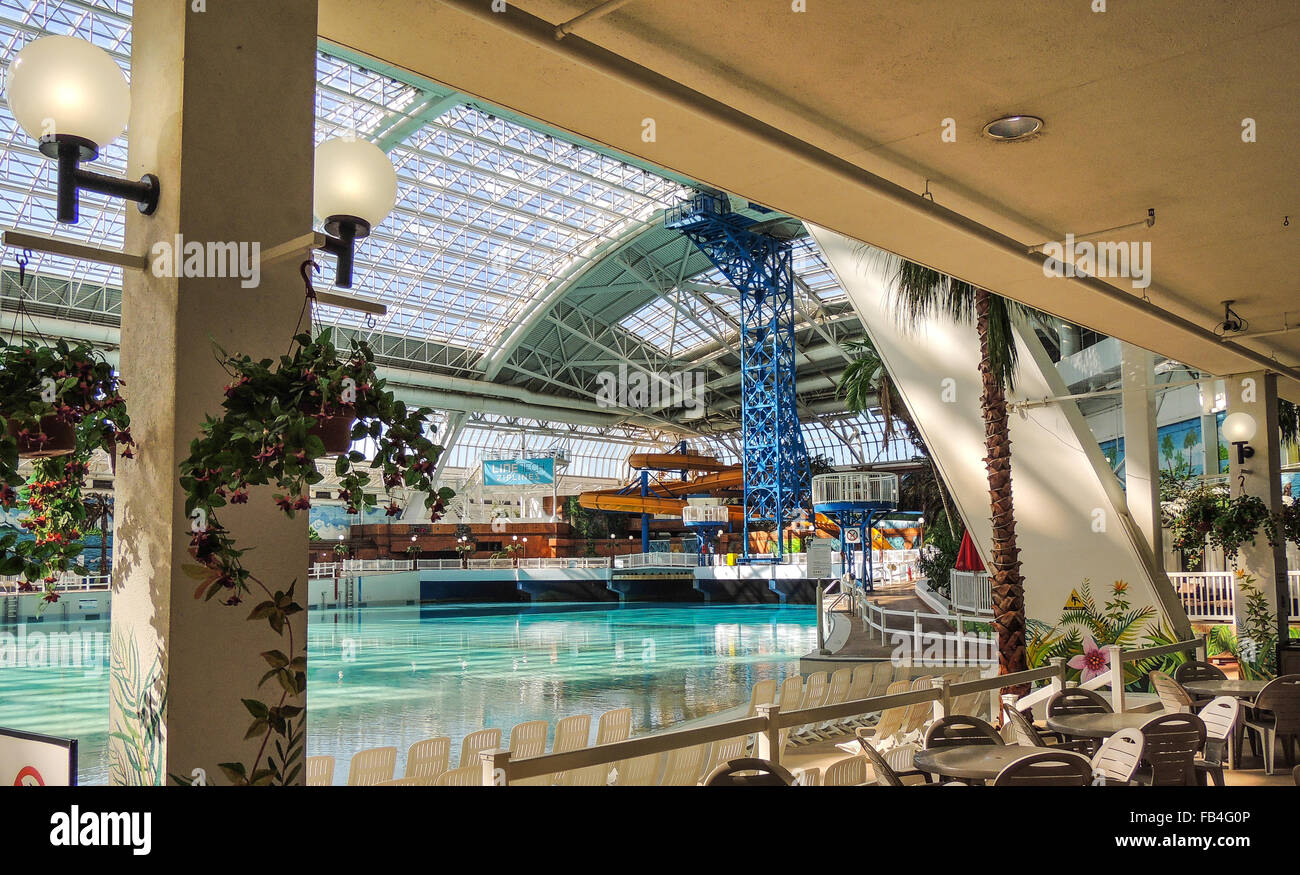 Piscina interna e un centro ricreativo con cafe cena tavoli e sedie Foto Stock