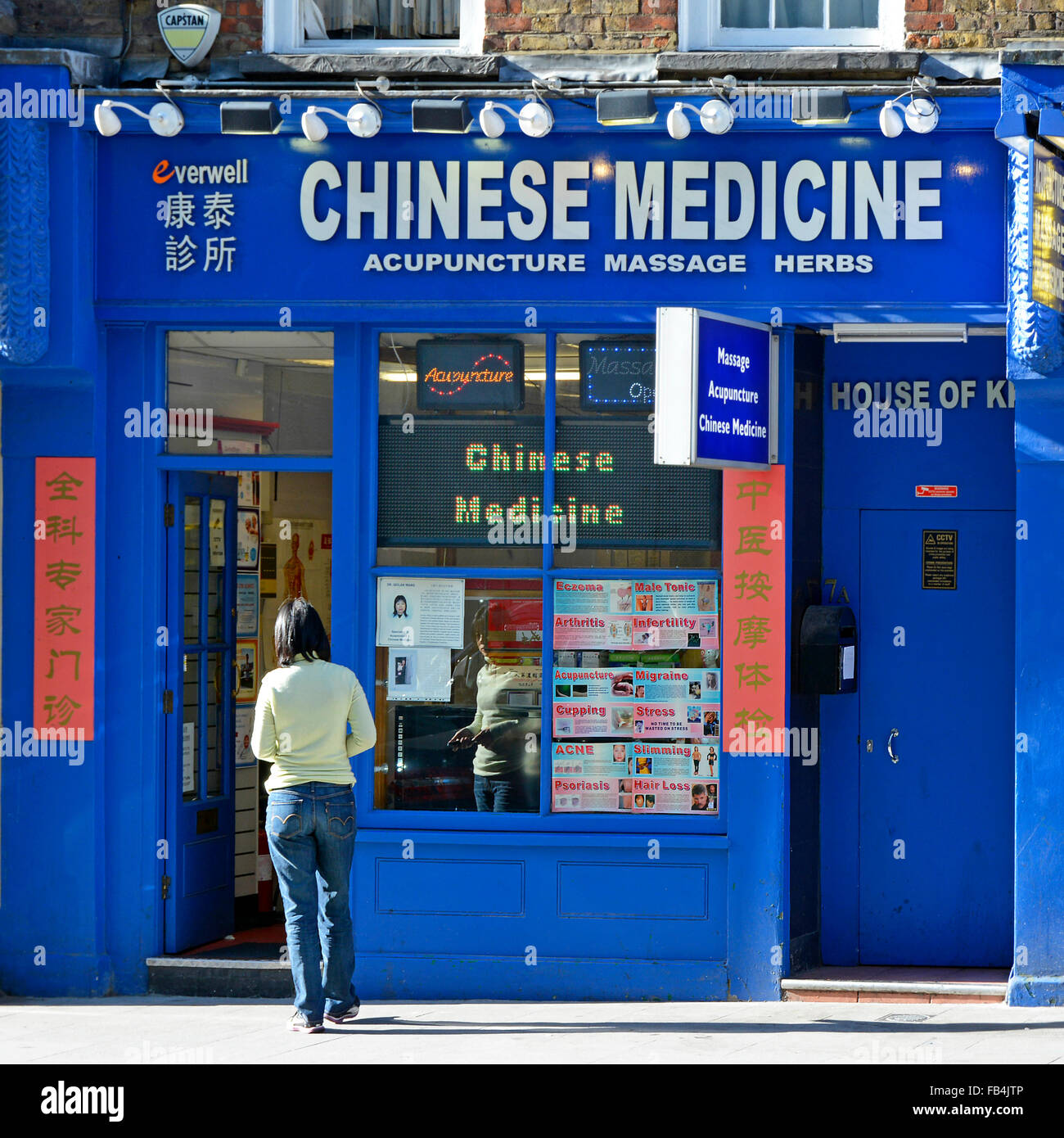 Vetrina e cartello di China Town per la Medicina Cinese Agopuntura Massage & Herbs business nel quartiere di Chinatown West End Londra Inghilterra Regno Unito Foto Stock