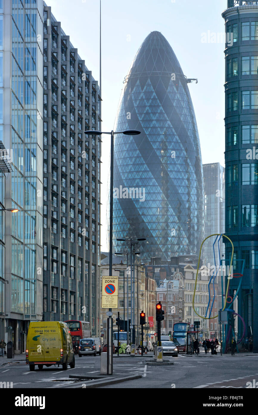 L'edificio Gherkin al 30 di St Mary Axe, un caratteristico grattacielo commerciale dalla forma insolita, domina l'estremità dello skyline della Città di Bishopsgate di Londra UK Foto Stock