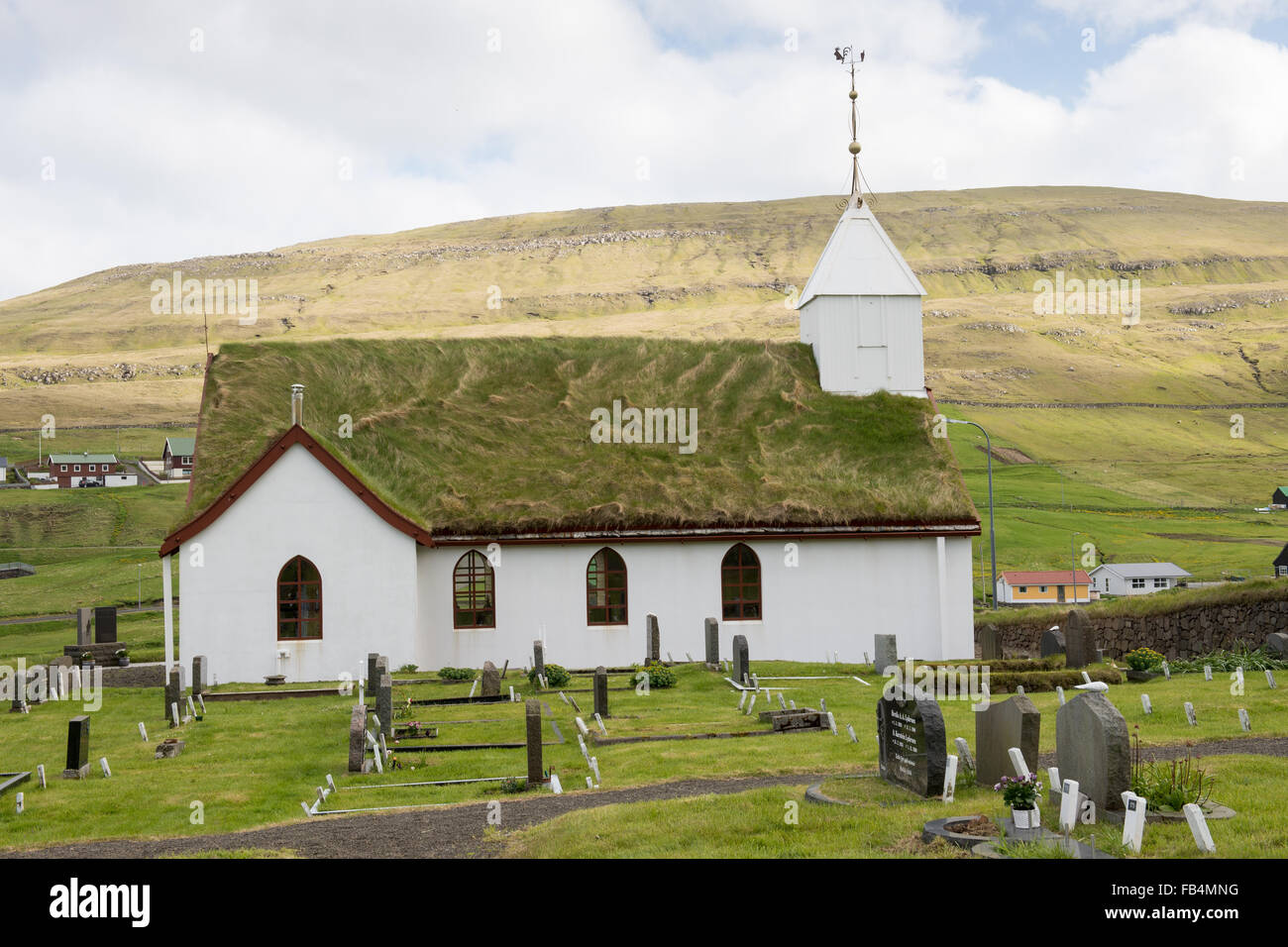 Chiesa in skalavik come visto dal cimitero fuori con il paesaggio e di montagna in background Foto Stock