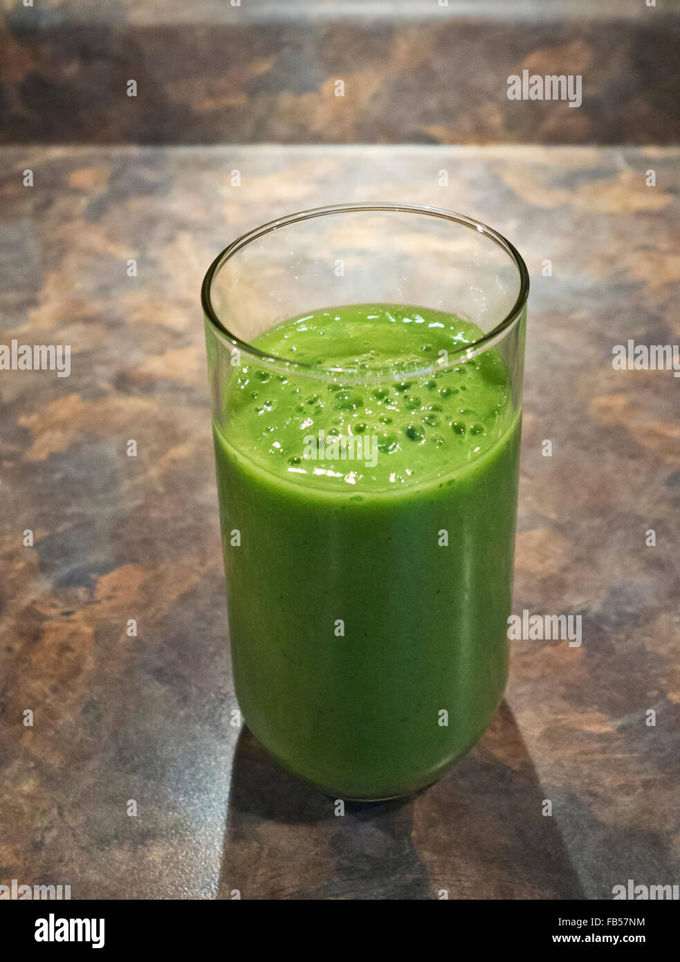 Schiumoso frullato verde. Il pupazzo di neve di vetro con una bevanda miscelata realizzato con sani verdi - Spinaci, kale e frutta. Fatta in Casa. Foto Stock