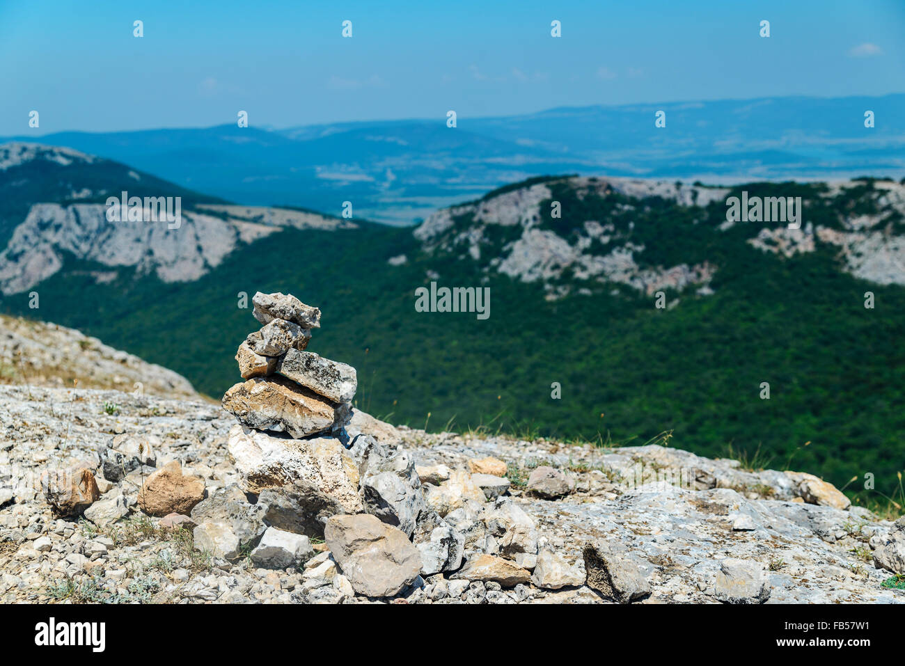 Cairn sulla cima di una montagna che domina la valle Foto Stock