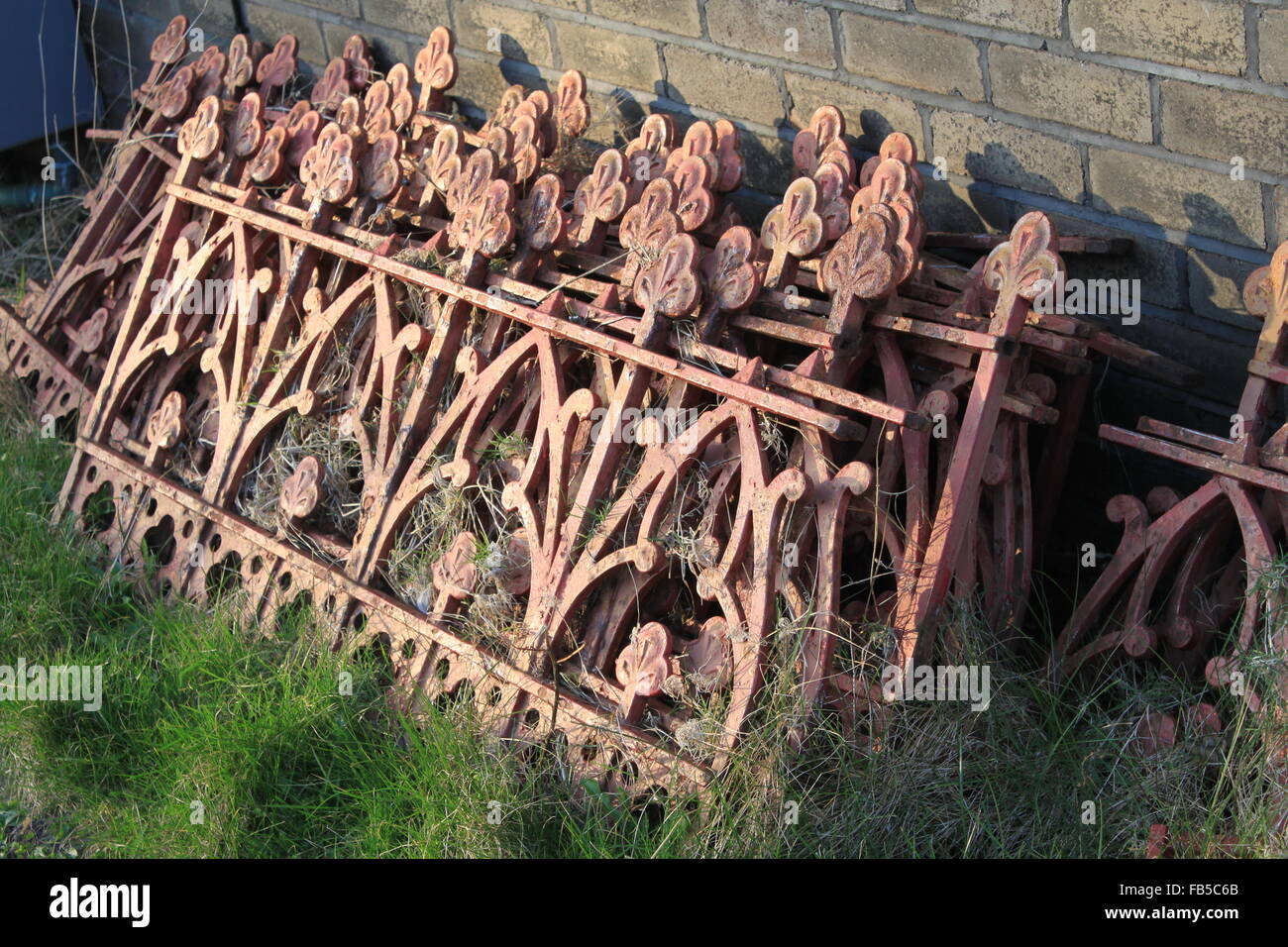 Pila di vecchi ringhiere in ferro sat sull'erba Foto Stock