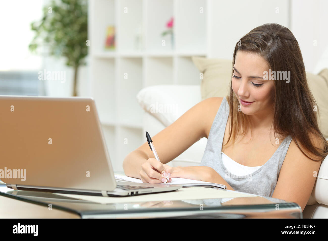 Imprenditore o studenti che lavorano o studiano a casa e scrivere note seduta sul pavimento a casa Foto Stock